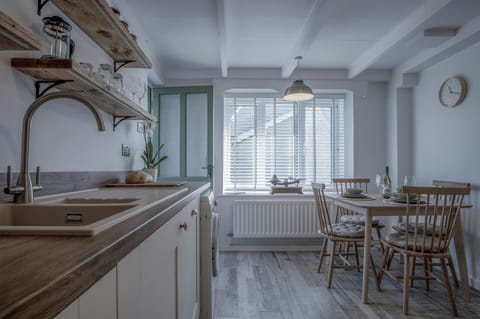 kitchen view facing window and wooden dining set