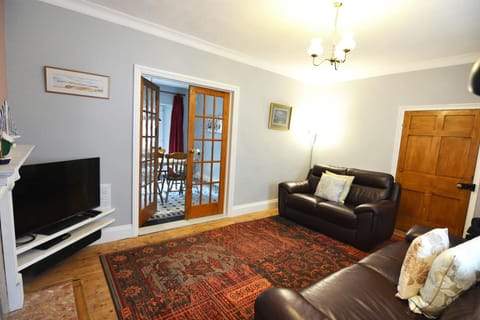 Lounge with two sofas, tv, double doors to dining room