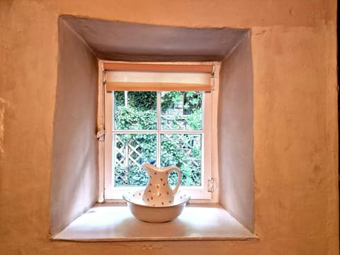 Small window and windowsill with bowl and jug