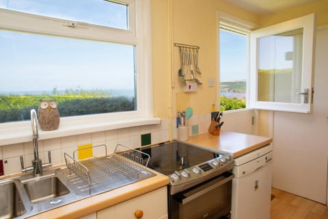 Kitchen with electric cooker, fridge and stable door leading to garden with distant sea views