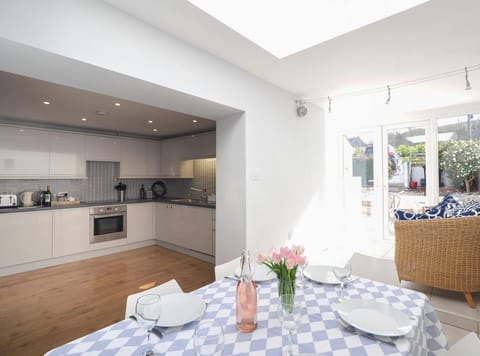 Dining table with blue and white table cloth and laid for dinner