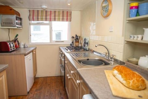 Kitchen with cooker and sink and loaf of bread on chopping board