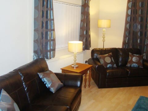 x2 leather two seater sofas, nest of tables with table lamp and floor lamp.