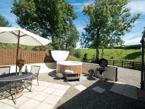 Patio with table, chairs, parasol and hot tub
