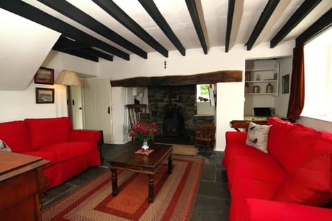 Two large sofas, standard lamp, coffee table on large rug, chairs and feature fireplace