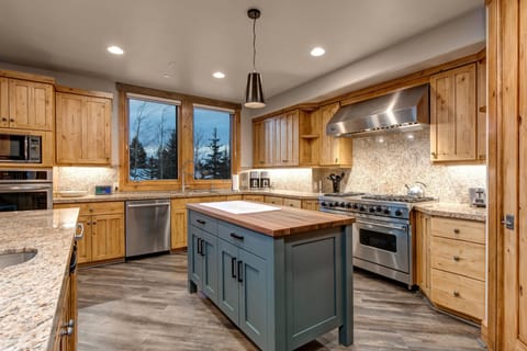 A kitchen with a stainless-steel stove and an island.