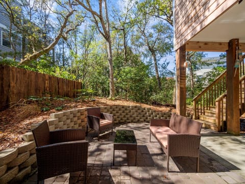 At the back of the house, there is a patio area with seating