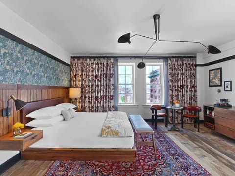 Unwind on crisp linens beside patterned wallpaper and city light
