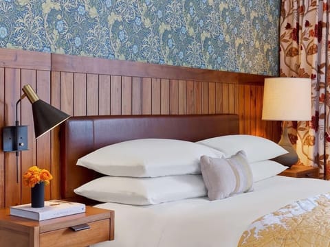 Sink into cloud-soft pillows under warm bedside lighting.