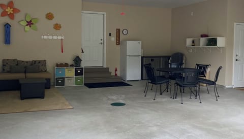 Garage area with patio sofa, table & chairs, and extra refrigerator.