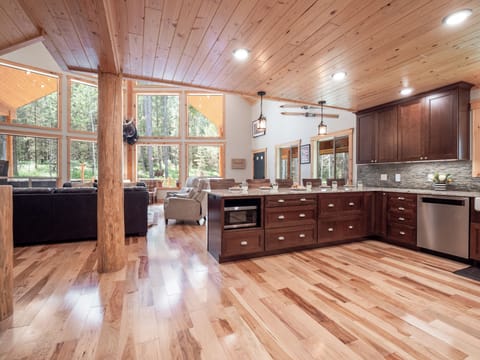 Enjoy seamless flow between the gourmet kitchen and grand living area, with floor-to-ceiling windows showcasing the breathtaking beauty of the surrounding wilderness.