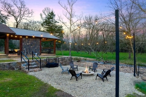 Firepit with string lights overlooking creek