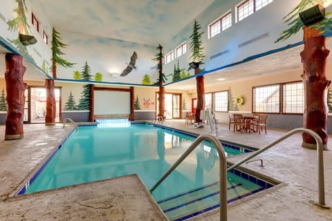 Dive into the stunning indoor pool beneath whimsical forest murals.