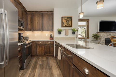 Your fully equipped kitchen features warm wood cabinetry, gleaming countertops, and modern appliances for creating memorable meals together.