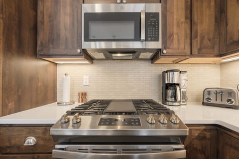 Your fully equipped kitchen features stainless steel appliances and warm wood cabinetry, perfect for preparing meals during your stay.