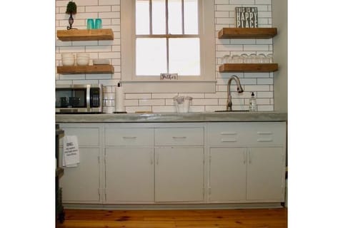 Mini kitchen with microwave, toaster oven, refrigerator, Keurig coffee station.
