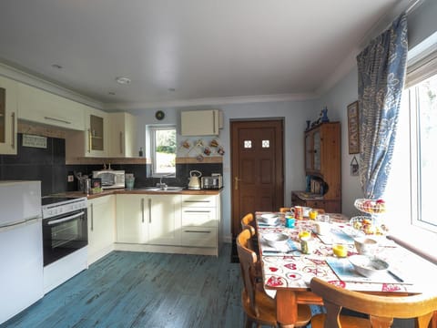 Dining table laid for breakfast and four chairs. Dresser