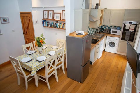 Open plan kitchen/dining area with wall mounted TV