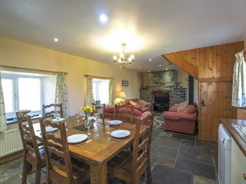 Dining table with six chairs leading to the lounge with sofas and armchairs