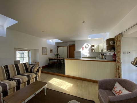 Living area with sofa, armchair, coffee table, dining table and 4 chairs