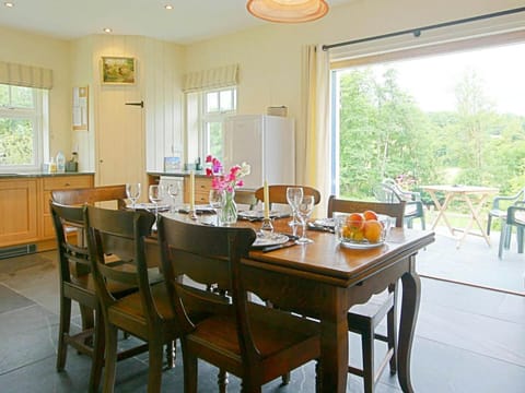 Dining area with table and seven chairs, fridge/freezer and doors leading to the patio with additional table & chairs outside
