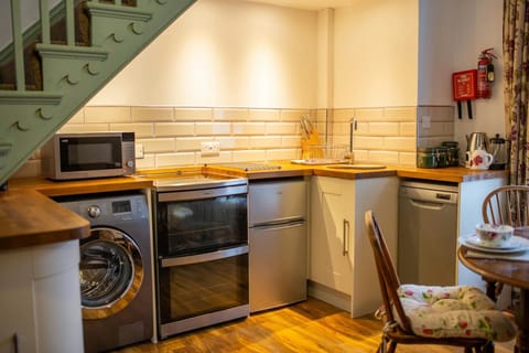 Electric hob and oven. Washing machine. Base cupboards with wooden work surface