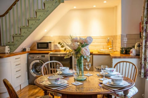 Dining table laid for dinner. Vase of flower in the centre of the table