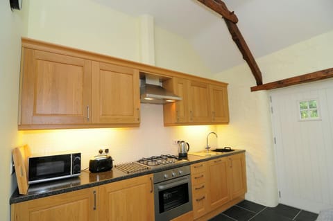 Fitted kitchen with sink, oven and gas hob, microwave, toaster and kettle