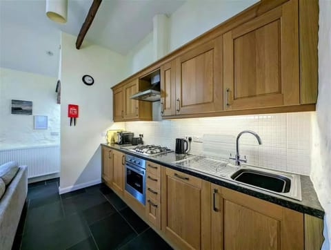 Fitted kitchen with sink, oven and gas hob, microwave, toaster and kettle