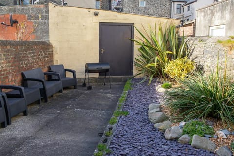 Court yard garden with patio chairs and BBQ