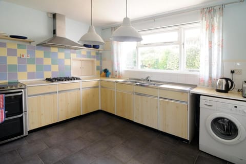 Kitchen with washing machine, oven and hob, kettle, toaster, sink and window
