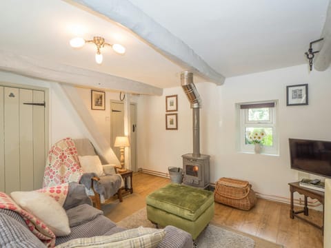 Living room with sofa, armchair, footstool, log burner