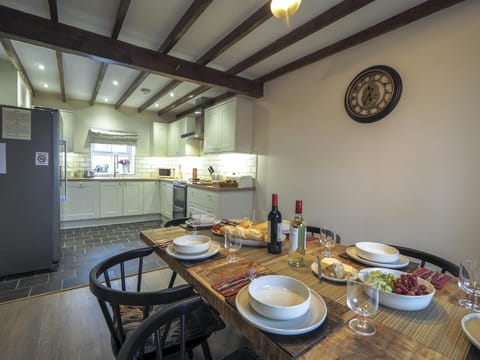 Dining are leading to kitchen. Wooden floors and beamed ceiling