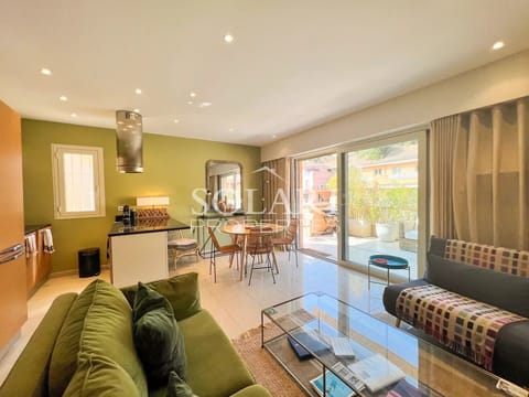 Living room with sofa, TV, dining area and open plan kitchen