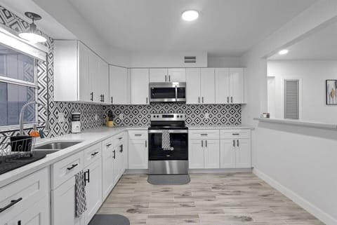 The kitchen is modern and elegant, with designer cabinets. It is a spacious area with lots of light.