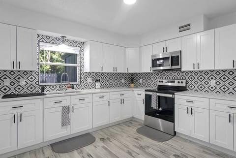 The kitchen is modern and elegant, with designer cabinets. It is a spacious area with lots of light.