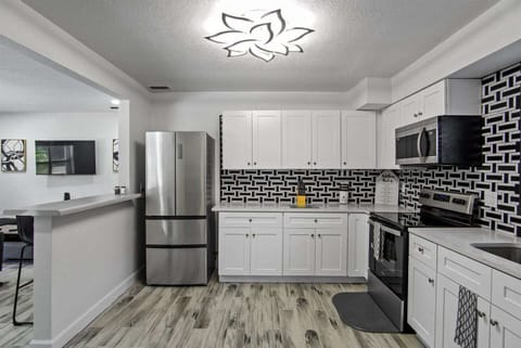 The kitchen is modern and elegant, with designer cabinets. It is a spacious area with lots of light.