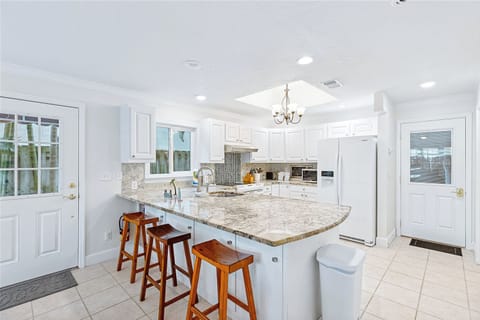 Bright and airy kitchen with marble counters and bar seating for gatherings.