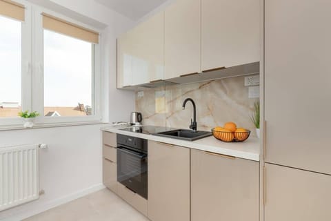 The kitchen's sleek design includes all necessary cookware and utensils. 