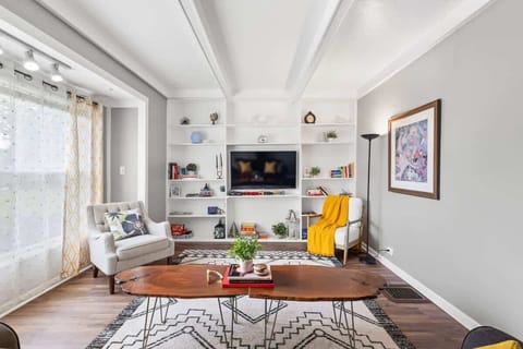 - Bright living room with built-in shelves and flat screen TV - Stylish wood coffee table and cozy armchairs add charm - Natural light and modern decor create a relaxing stay