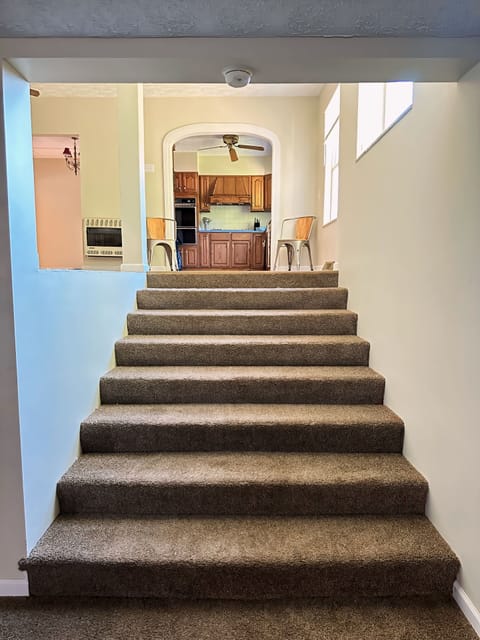 Large, oversized stairway from entertainment living room to dining & kitchen