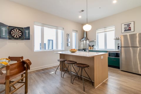 Sleek kitchen features an island with barstool seating.