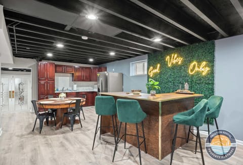 Get the party started at the custom wood bar in the basement, stocked with seating for the whole crew. With a full kitchenette, mini fridge, and a neon Vibe Only sign setting the mood, this space was made for a good time.