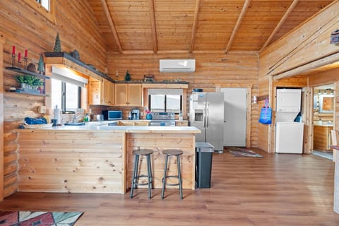 Open concept kitchen with vaulted ceilings, full appliances, and island seating.