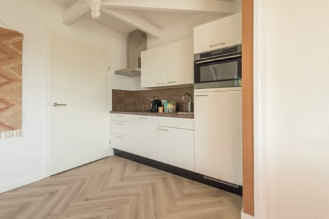 A fully equipped kitchen featuring sleek cabinetry, a built-in microwave, and a contemporary backsplash, perfect for convenient cooking.