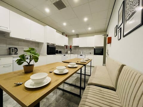 Spacious shared kitchen with modern appliances, a cozy dining bench, and a welcoming atmosphere for group meals.