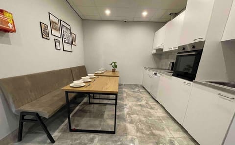 Fully equipped shared kitchen featuring ample seating, modern appliances, and a welcoming dining area for all guests.