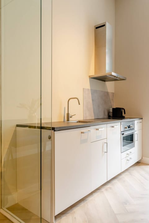 A clean and minimalistic kitchen with modern appliances, providing a practical and stylish cooking space.