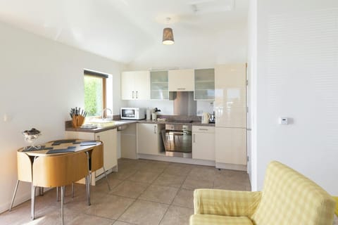 Open plan, well equipped fitted kitchen/dining area: table with four chairs and armchair