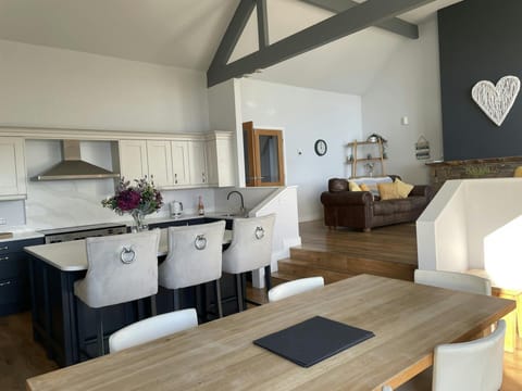 Open plan kitchen/diner, dining table, kitchen island with three bar stools